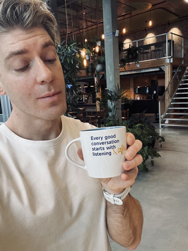 Nick holding a mug about listening during a workday