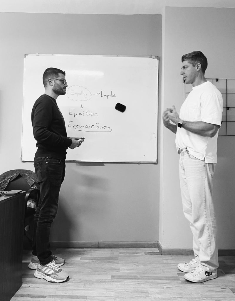 Nick in conversation beside a whiteboard during a workshop